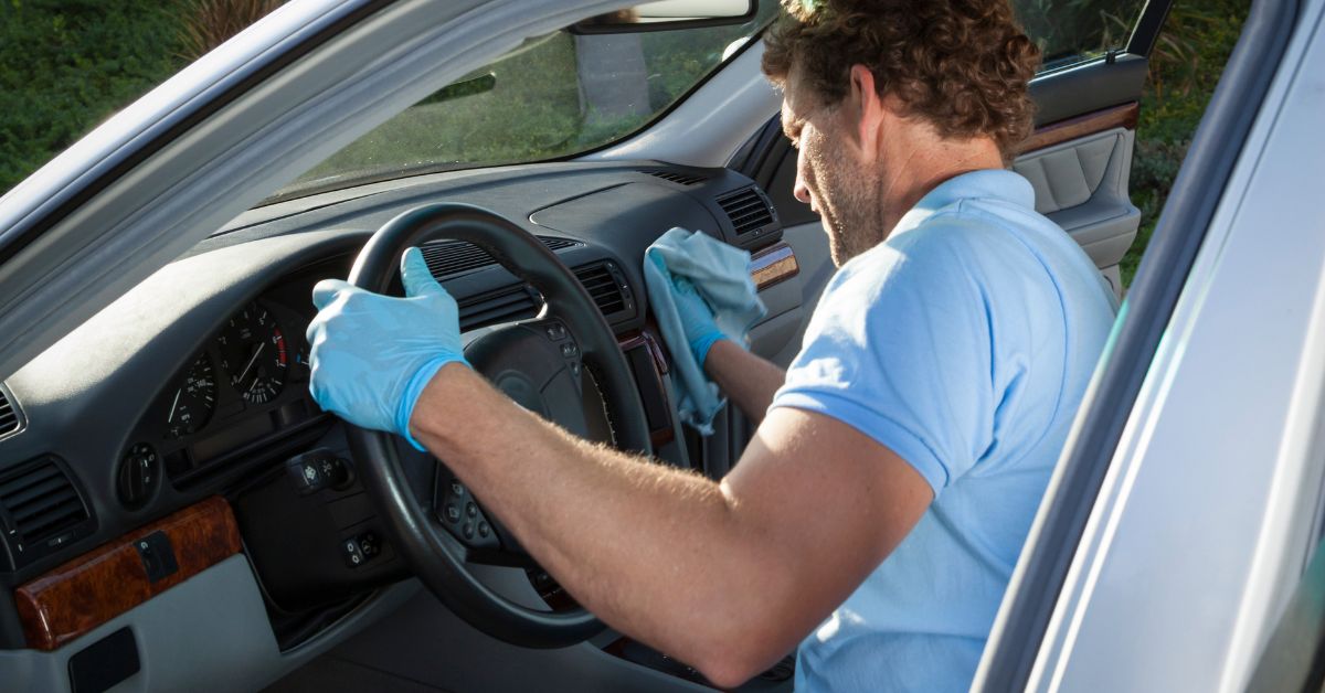 Person cleaning a car dashboard