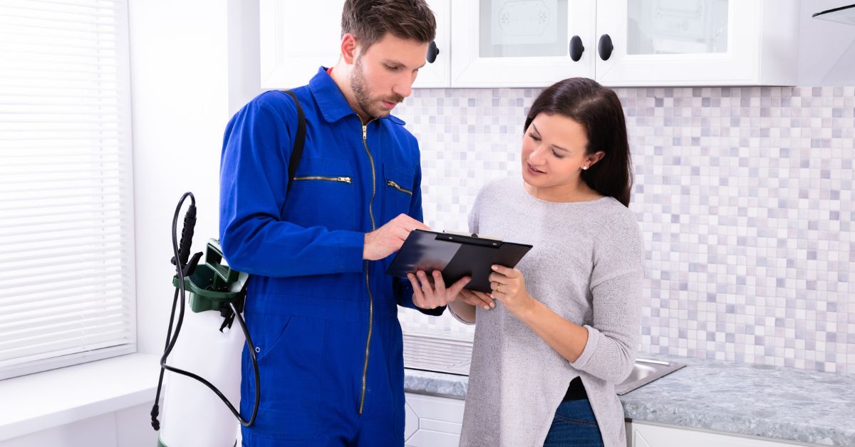 Pest control professional showing a client a quote on an ipad